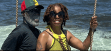 a man wearing a hat with a marijuana leaf on it sits next to a woman wearing sunglasses