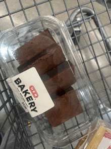 a container of brownies from the heb bakery sits in a shopping cart