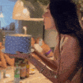 a woman is blowing out a candle on a cake