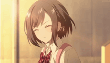 a girl with short brown hair is wearing a school uniform and a red plaid tie