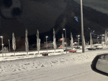 a snowy parking lot with cars parked in it