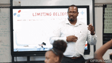 a man stands in front of a whiteboard with the words limiting beliefs on it