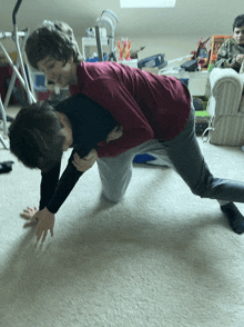 a boy in a red shirt is carrying another boy in a black shirt on his back