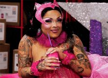 a woman in a pink costume drinking from a pink cup