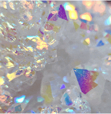 a close up of a white crystal with iridescent triangles