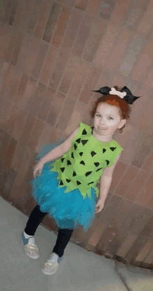 a little girl in a flintstones costume is standing on a sidewalk