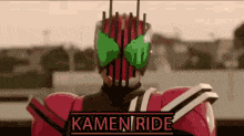 a kamen rider is wearing a red and black suit with a green mask .