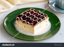 a piece of cake on a green plate with milk