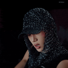 a close up of a person wearing chain mail and a hat