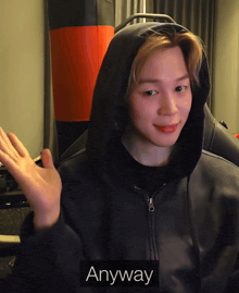 a person wearing a black hoodie with the word anyway on the bottom