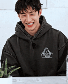 a young man wearing a hoodie that says palace