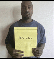 a man is holding a piece of paper that says " bro stop "