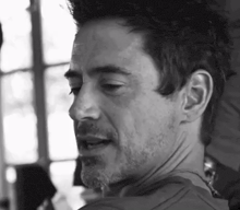 a black and white photo of robert downey jr. with a beard and mustache .