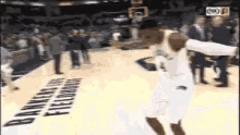 a basketball player is jumping in the air while holding a basketball in front of a banner that says bankers hill fieldhouse