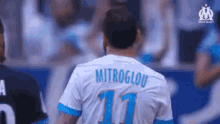 a soccer player wearing a white and blue jersey with the number 11 on it