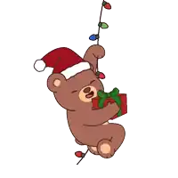 a brown teddy bear wearing a santa hat and holding a gift