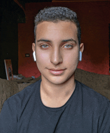 a young man wearing a black shirt and white earbuds