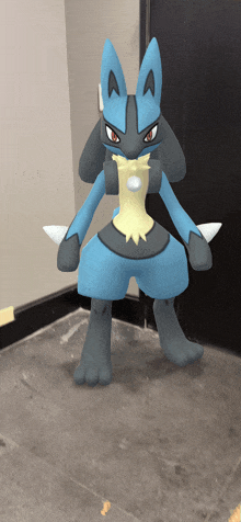 a blue and black pokemon with red eyes is standing in a hallway