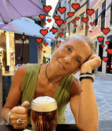 a woman is sitting at a table with a glass of beer in front of a store that says mizani