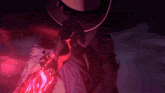a person wearing a cowboy hat is holding a red object in their hand