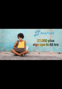 a woman sits on the ground with her legs crossed using a laptop computer