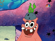 patrick star from spongebob squarepants is wearing a rock on his head and smiling .