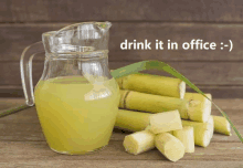 a pitcher of sugar cane juice next to a pile of sugar canes