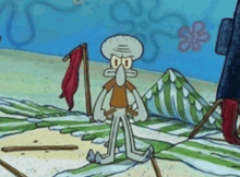 squidward from spongebob squarepants is standing on a beach with a striped towel .