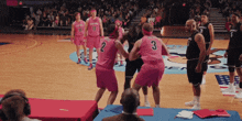 a group of basketball players wearing pink jerseys with the number 2 and 3 on them