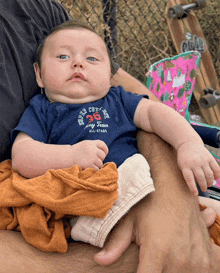 a baby wearing a shirt that says my team on it