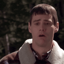 a man with a surprised look on his face wearing a plaid jacket