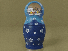 a blue russian nesting doll with flowers and the word education on the top