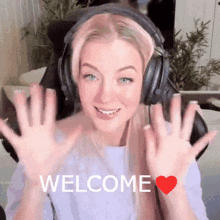 a woman wearing headphones says welcome with a heart in the corner