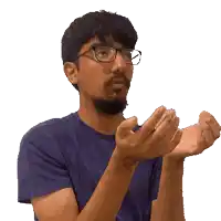 a man wearing glasses and a blue shirt holds something in his hands