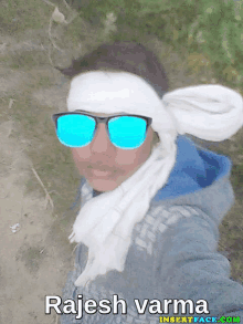 a person wearing sunglasses and a scarf with the name rajesh varma