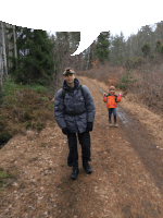 a man and a child are walking on a dirt path