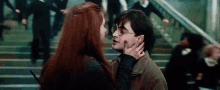 harry potter and ginny weasley are kissing in front of a crowd of people on stairs .