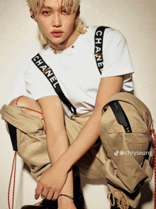 a young man wearing a white chanel shirt