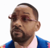 a man with a beard wearing sunglasses and a pink shirt .