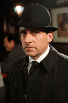 a man wearing a black hat and a trench coat