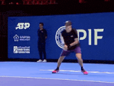 a man is playing tennis in front of a sign that says pif
