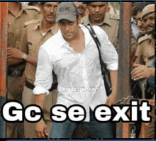 a man in a white shirt is standing in front of a group of police officers with the caption " gc se exit "