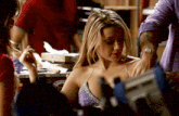 a woman in a purple bra is looking down at her breasts