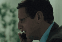 a man with glasses is talking on a cell phone