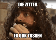 a man with a beard is covered in feathers with the caption die zitten er ook tussen