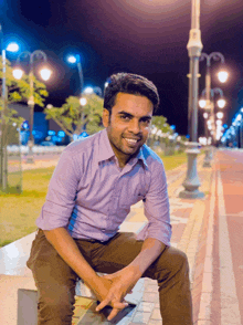 a man in a purple shirt is sitting on a bench