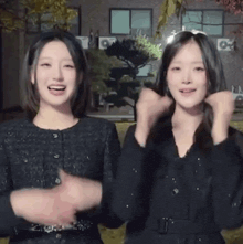 two young women are standing next to each other and making funny faces .