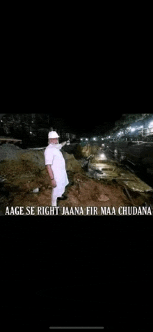 a man in a hard hat is standing in front of a pile of dirt .