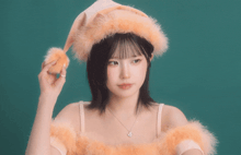 a woman wearing a santa hat and a necklace looks to the side