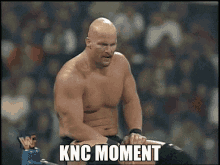 a shirtless wrestler is sitting in a ring with the words knc moment written on the bottom